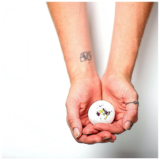 A Bath Bomb being held in palm of woman's hands by Archaic Revival.